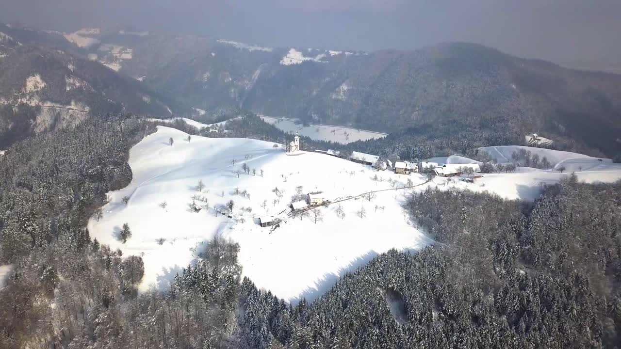 겨울 동안 중앙 슬로베니아의 언덕 꼭대기에 있는 그림 같은 스베티 토마즈 교회