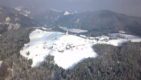 la pintoresca iglesia de sveti tomaz en la cima de la colina en el centro de eslovenia durante el invierno