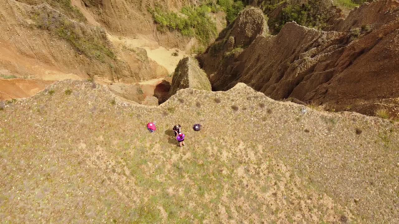 Two Female Hikers On The Mountain Top With Their Backpacks On The Ground. Hiking In Huaraz, Peru. aerial pullback tilt-up