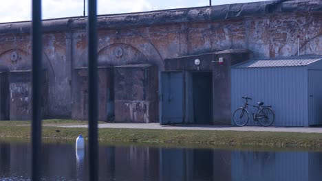 Exterior-of-the-entrance-into-the-concrete-bomb-shelter-to-hide-civil-people,-an-underground-apocalypse-bunker-built-in-old-coastal-fortification,-sunny-day,-distant-medium-shot