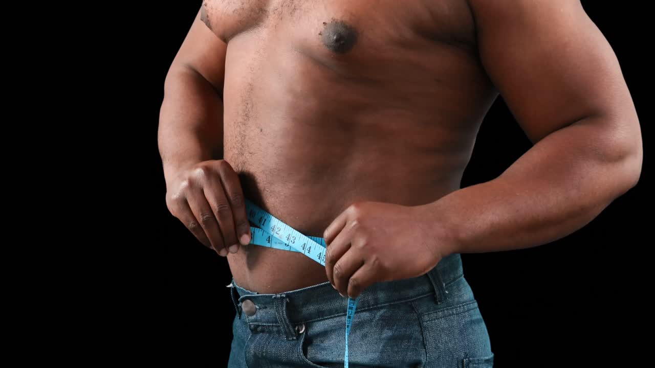 hombre musculoso midiendo su cintura