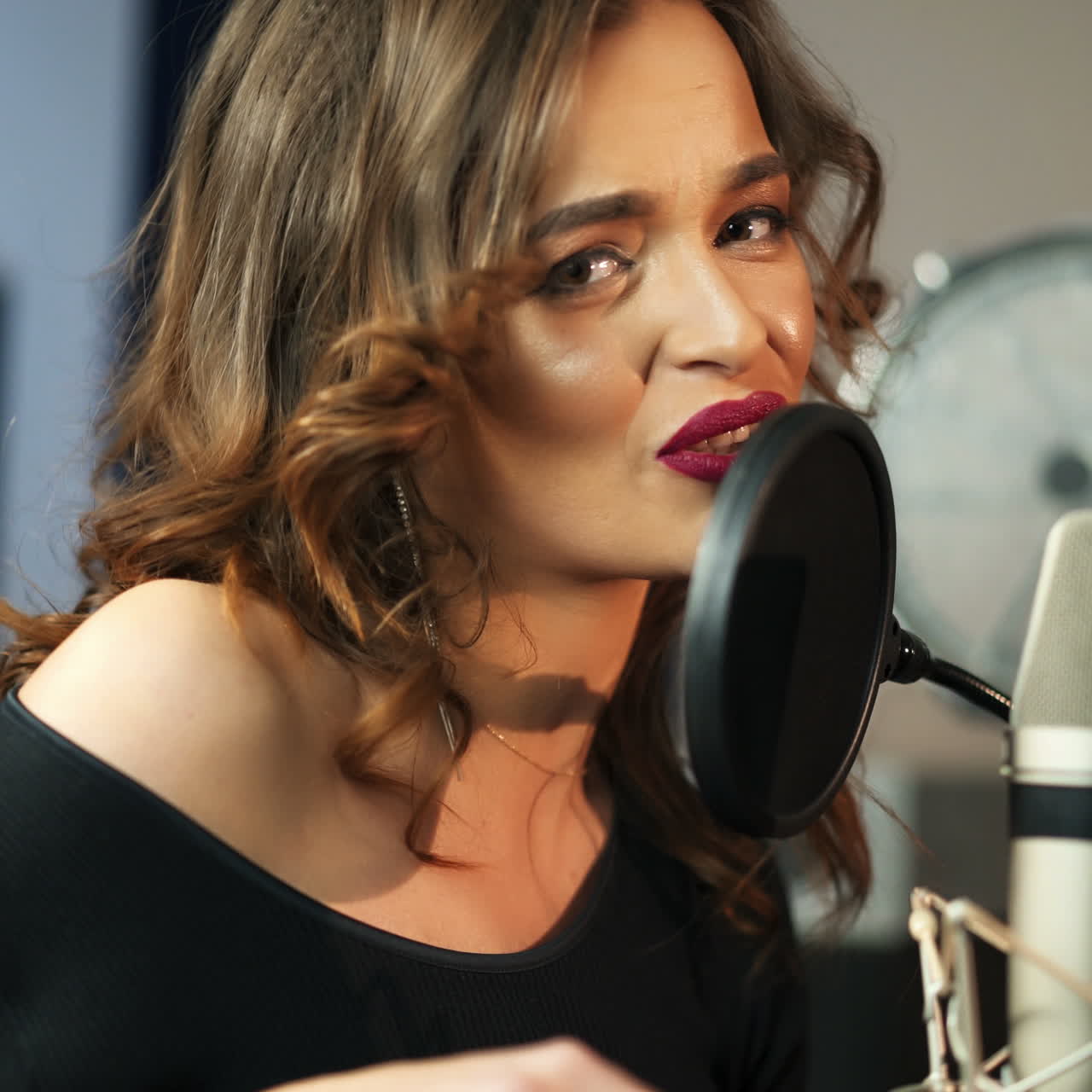 Young female singer recording album in the professional studio. Woman singing a song in music recording studio. Square video