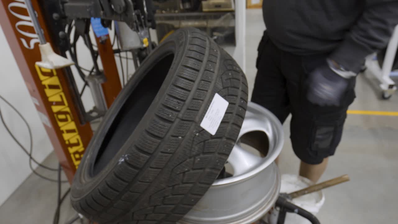 Mechanic Changing a Tire on a Tire Mounting Machine