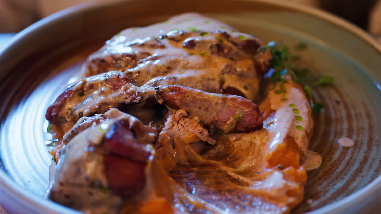 Close up of meat being cut over a bed of a sweet potato puree at a restaurant