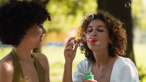 Una pareja soplando burbujas en el parque.