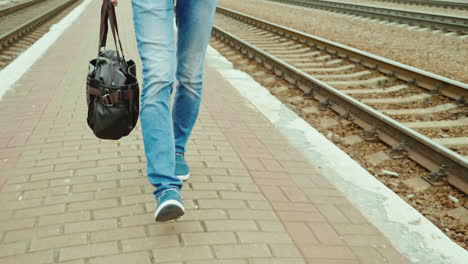 a man with a travel bag goes along the railroad 1