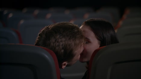 Young-guy-and-girl-indulge-in-passion-in-cinema-after-film.-Kissing-couple