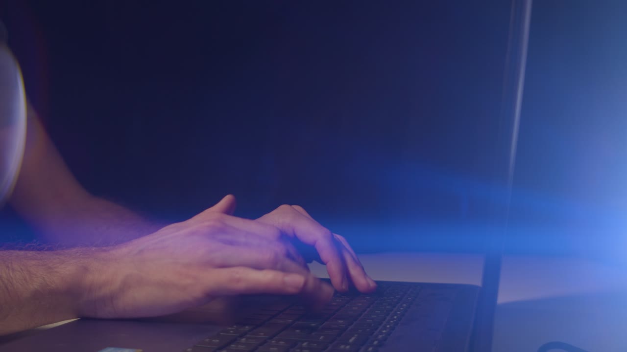 Working from home male hands typing on a laptop with cinematic lens flare