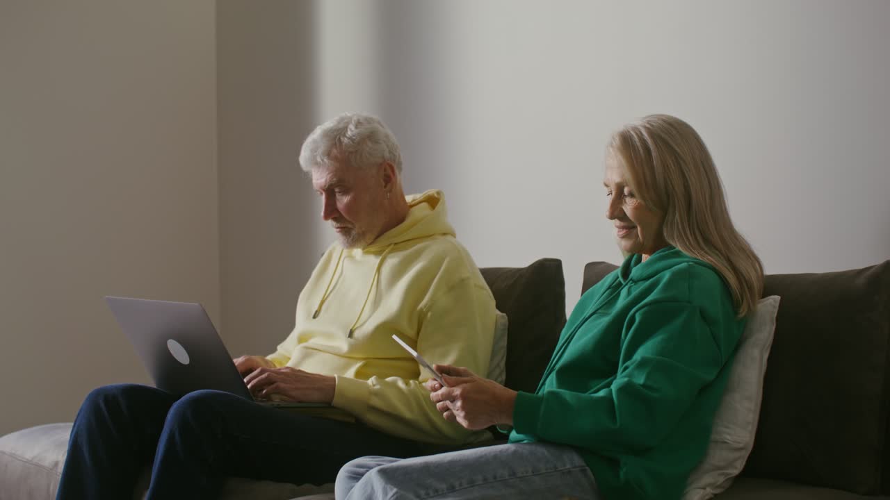 пожилая пара использует ноутбук и планшет