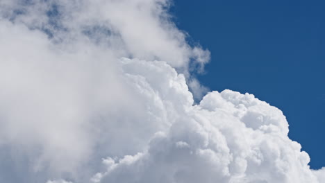 fluffy white clouds forming against deep blue sky in a peaceful timelapse scene