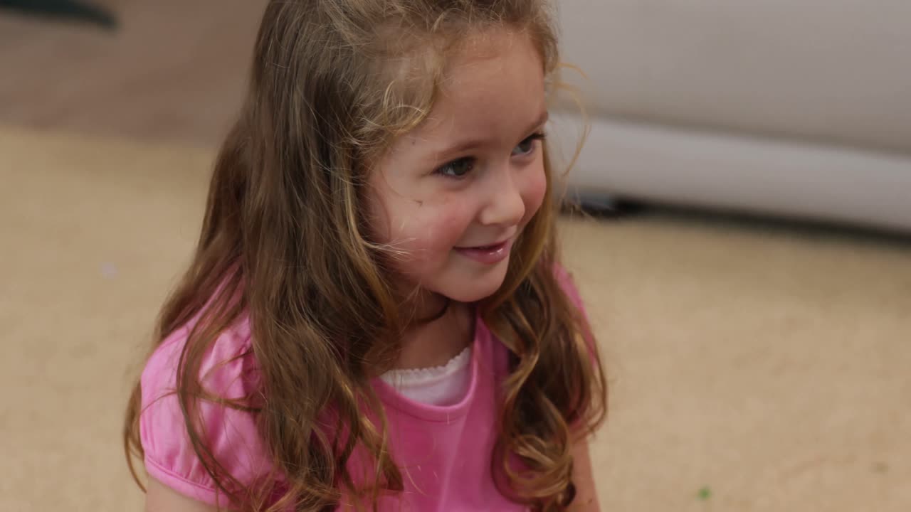 una niña sentada en el suelo sonriendo