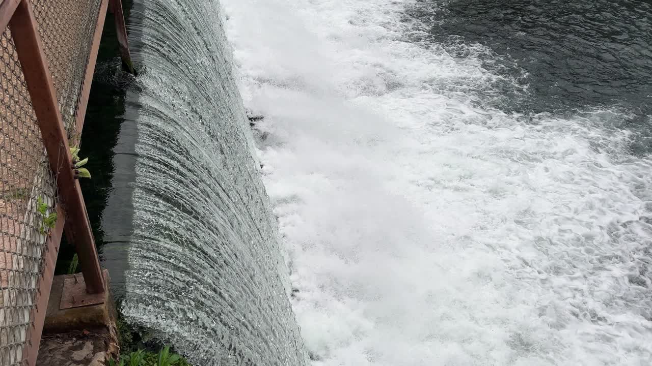 closeup of fast moving water thru a dam 4k 30fps drone angle