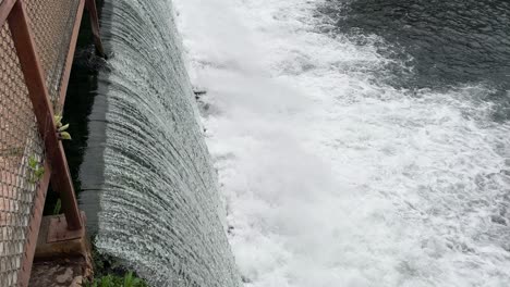 primer plano de agua en movimiento rápido a través de una presa ángulo de dron 4k 30fps