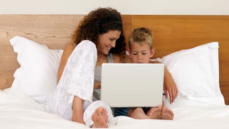 Madre-E-Hijo-Usando-Laptop-Acostados-En-La-Cama