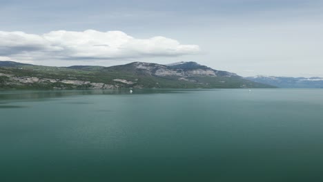 Lake-water-basin-in-front-of-a-small-village-in-Gäsi-Betlis,-Walensee-Glarus,-Weesen-Walenstadt,-Switzerland--drone-aerial