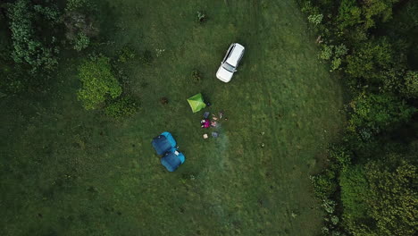 4k-drone-view-from-above-of-a-small-camp-of-three-people-in-the-Mau-Forest,-Rift-Valley,-Kenya