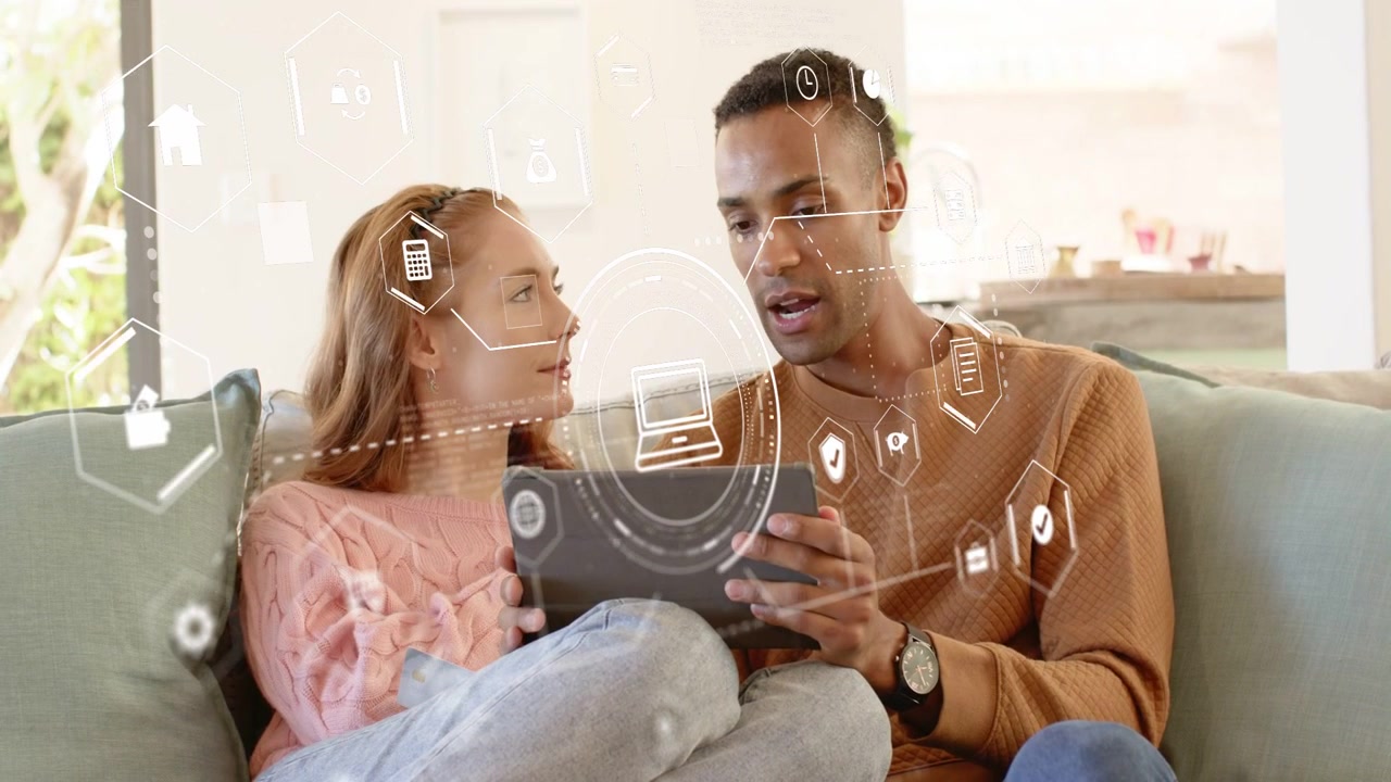 Couple sitting on sofa sharing tablet touching screen causing tech overlays reviewing content