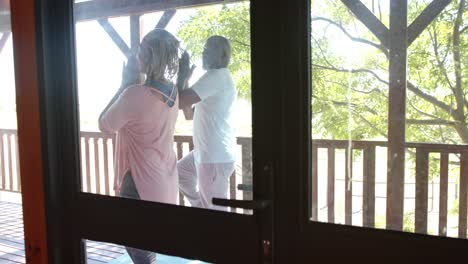 Senior-african-american-couple-practicing-yoga-on-sunny-terrace,-slow-motion