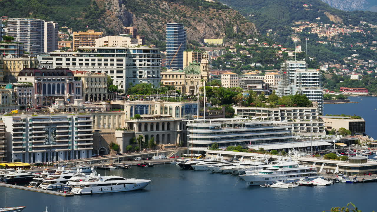 Aerial view of white boats docked in the Monaco Marina with the skyline on the background