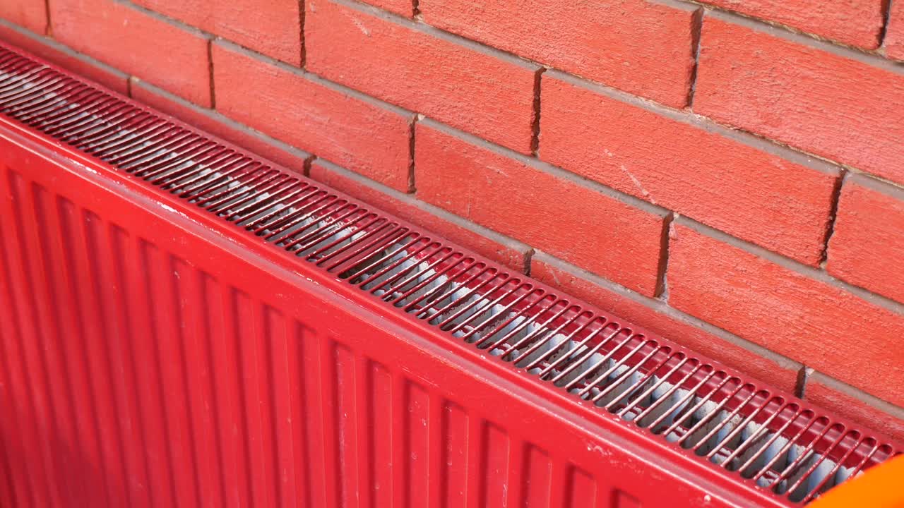 Red Radiator Against Brick Wall