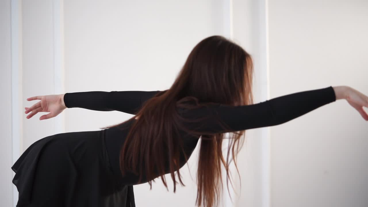 검은 드레스 를 입은 여자 가 현대 춤 을 연주 하고 있다