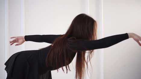 una mujer con un vestido negro realizando una danza moderna.