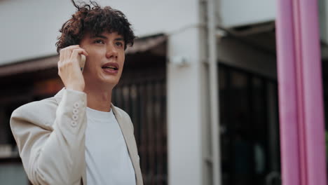 man in white suit talking on the phone