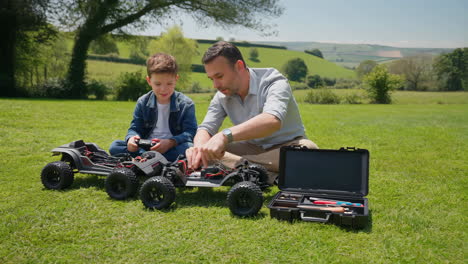 father and son bonding while assembling remote control cars outdoors
