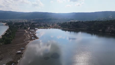 Luftaufnahme-Eines-Flachwasserbereichs,-Während-Sich-Wolken-Und-Berge-Auf-Der-Wasseroberfläche-Spiegeln