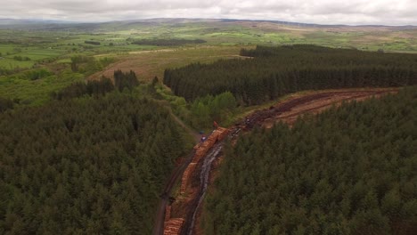 forestry and logging operations taking place in the highlands of scotland using large industrial machinery, ships and trucks