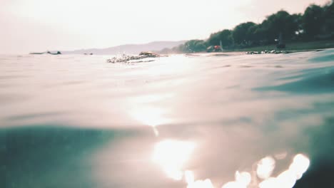 hombre atlético se sumerge bajo el agua en el mar a cámara lenta cinematográfica