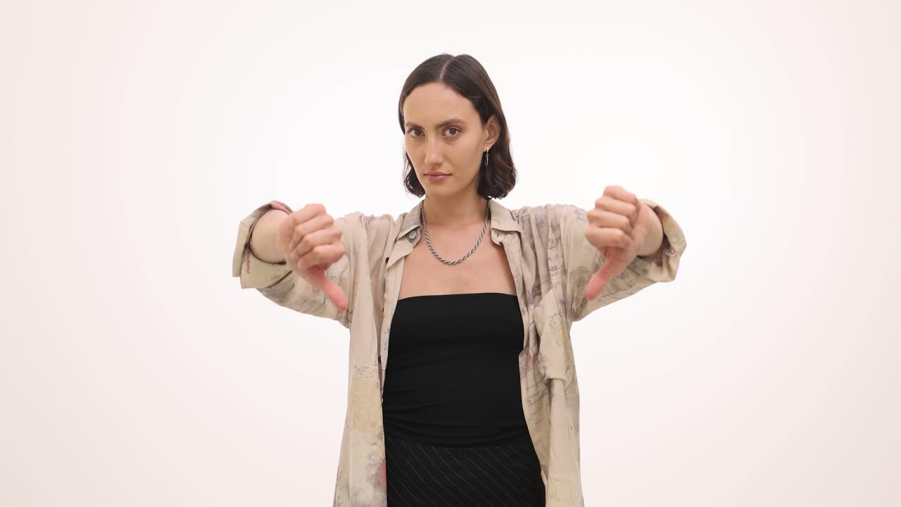 A woman giving two thumbs down gestures