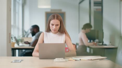 Business-woman-working-at-laptop-at-coworking.-Portrait-of-concentrated-lady.