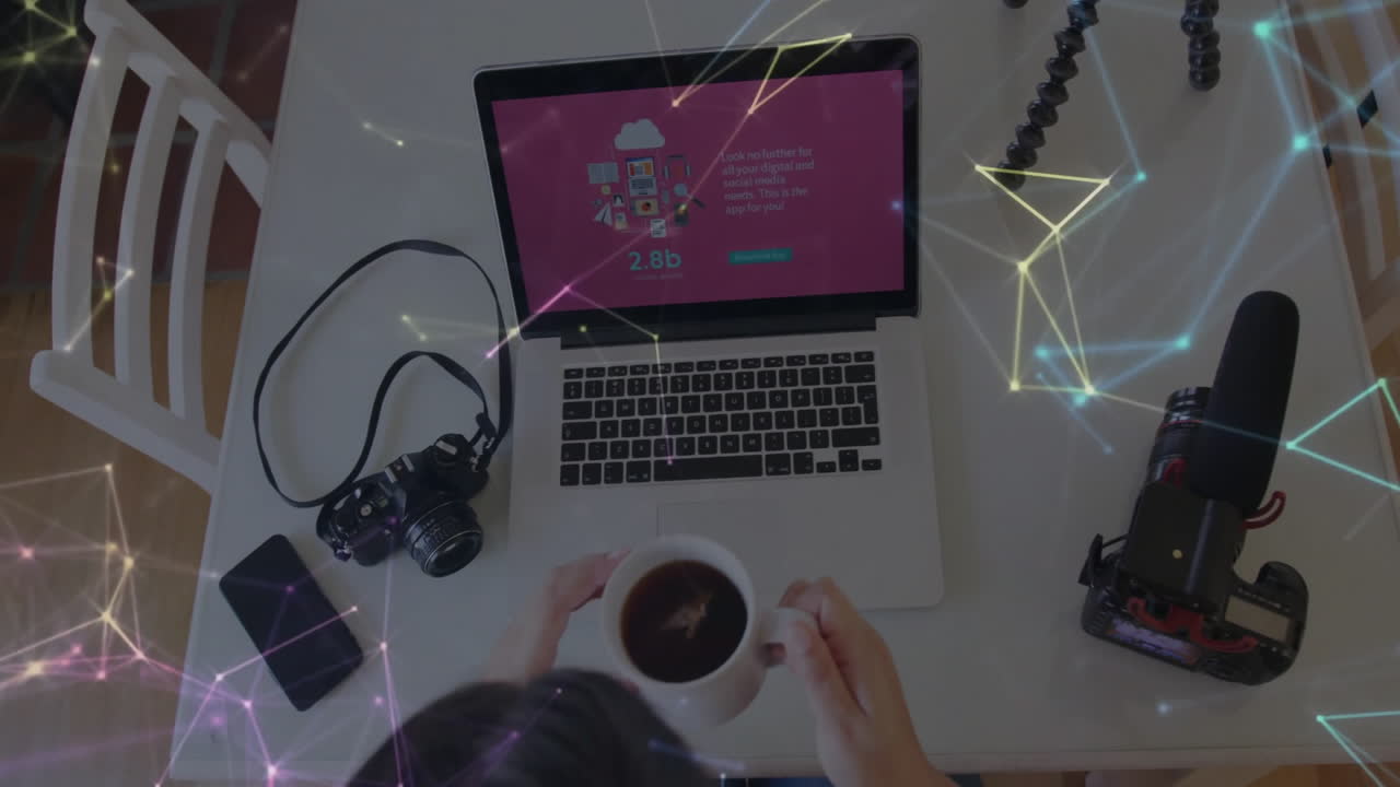 Content creator holding coffee mug at home studio, showing glowing network nodes over laptop