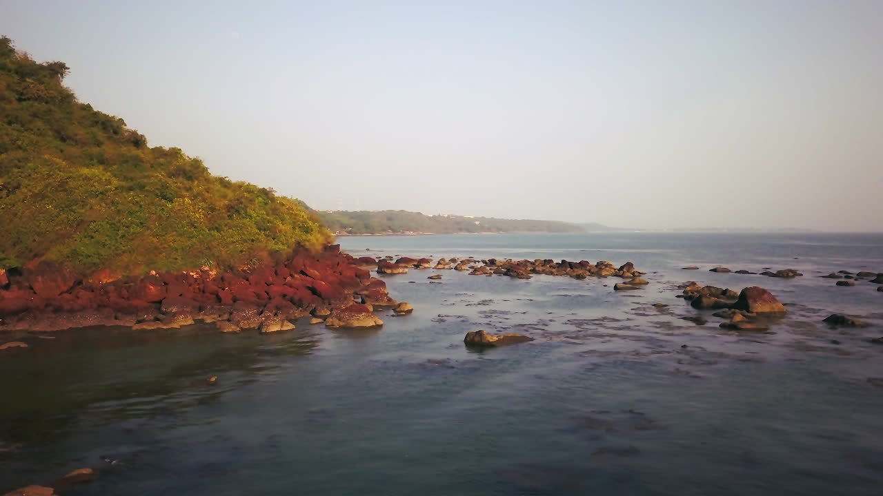 india trópico goa en la bahía del mar arábigo océano índico puesta de sol de playa y rocas pan cinemático círculo a la derecha