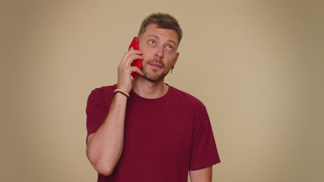 tired young man making online conversation speaks on smartphone, boring call, nonsense talking