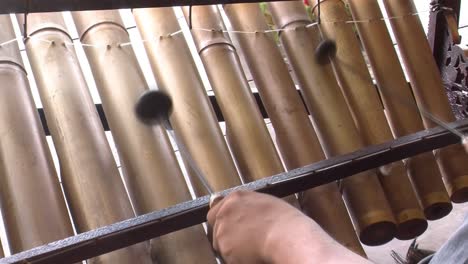 músico tocando rindik, instrumento musical tradicional de bali