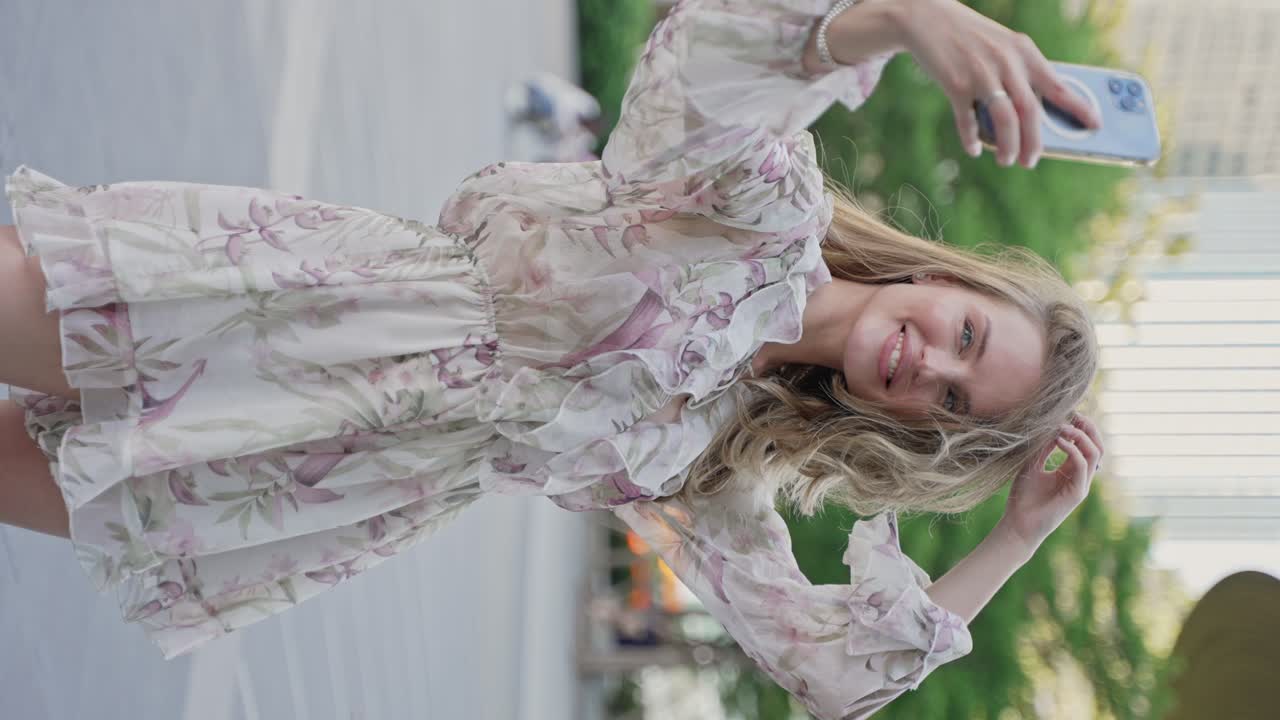 거리에서 꽃 드레스를 입고 셀피를 찍는 여자