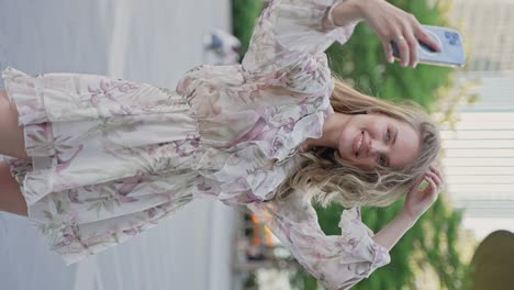 woman taking a selfie in a floral dress on the street