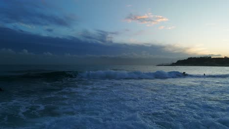 Group-of-surfers-at-dusk,-Varazze-in-Liguria,-Italy