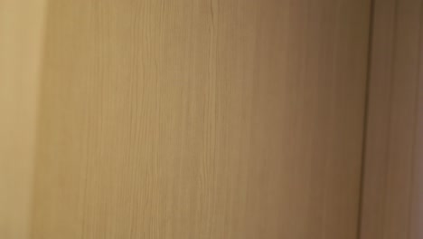 man's hand knocking at the hotel's door with his knuckles