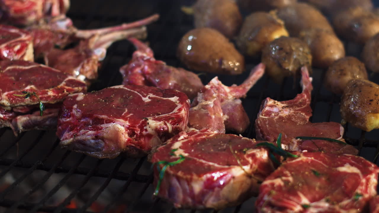 las manos del chef de primer plano cocinando costillas de carne con verduras. patatas a la parrilla.