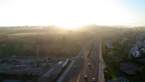 aerial view of coastal highway with hazy sunrise and residential area