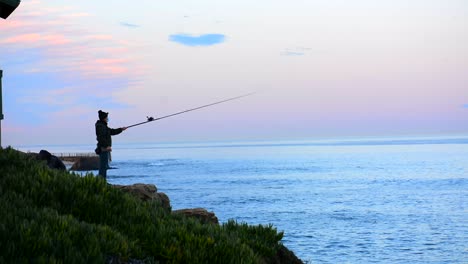 fisherman casting rod into pacific ocean at la jolla california
