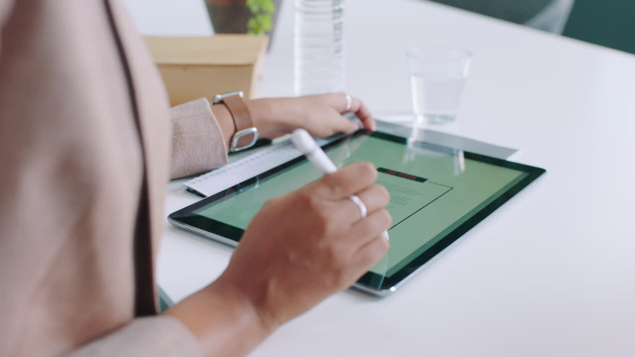 Person Using Digital Tablet with Stylus in Modern Office
