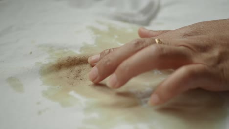 primer plano de una mancha marrón en una camisa blanca
