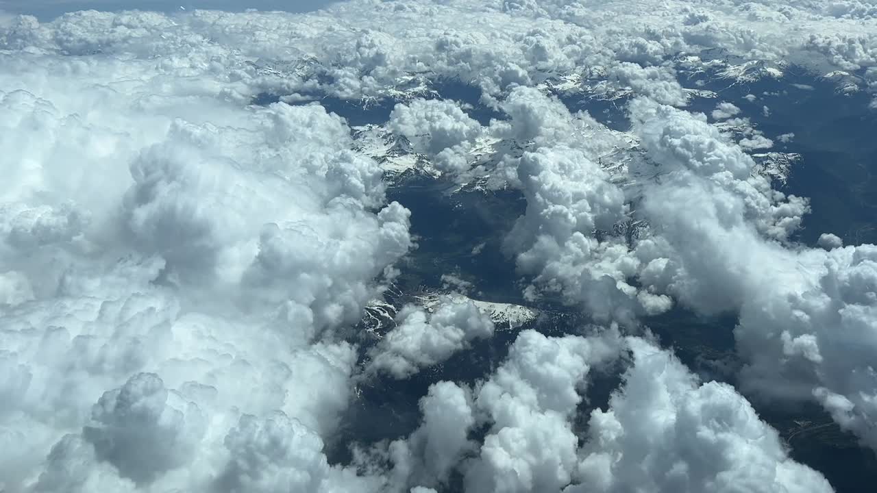 vista aérea desde una cabina de jet mientras sobrevuela las montañas de los alpes cubiertas de nieve