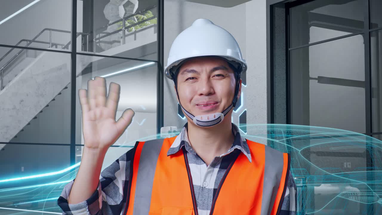 안전 헬을 입은 아시아 남성 엔지니어가 카메라를 향해 미소 짓고 손을 흔들며 작별 인사를 하고 있다.