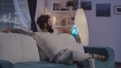 man relaxing on sofa with holographic projection