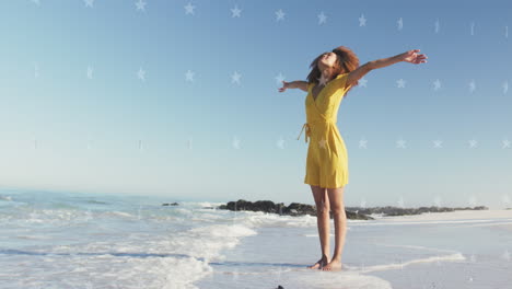 animación de estrellas sobre mujer afroamericana levantando las manos en la playa